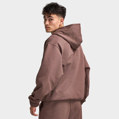 Unlike Humans Ridge Hoodie. Back three-quarter view of model wearing coffee quarts hoodie with raised hood and loose silhouette.